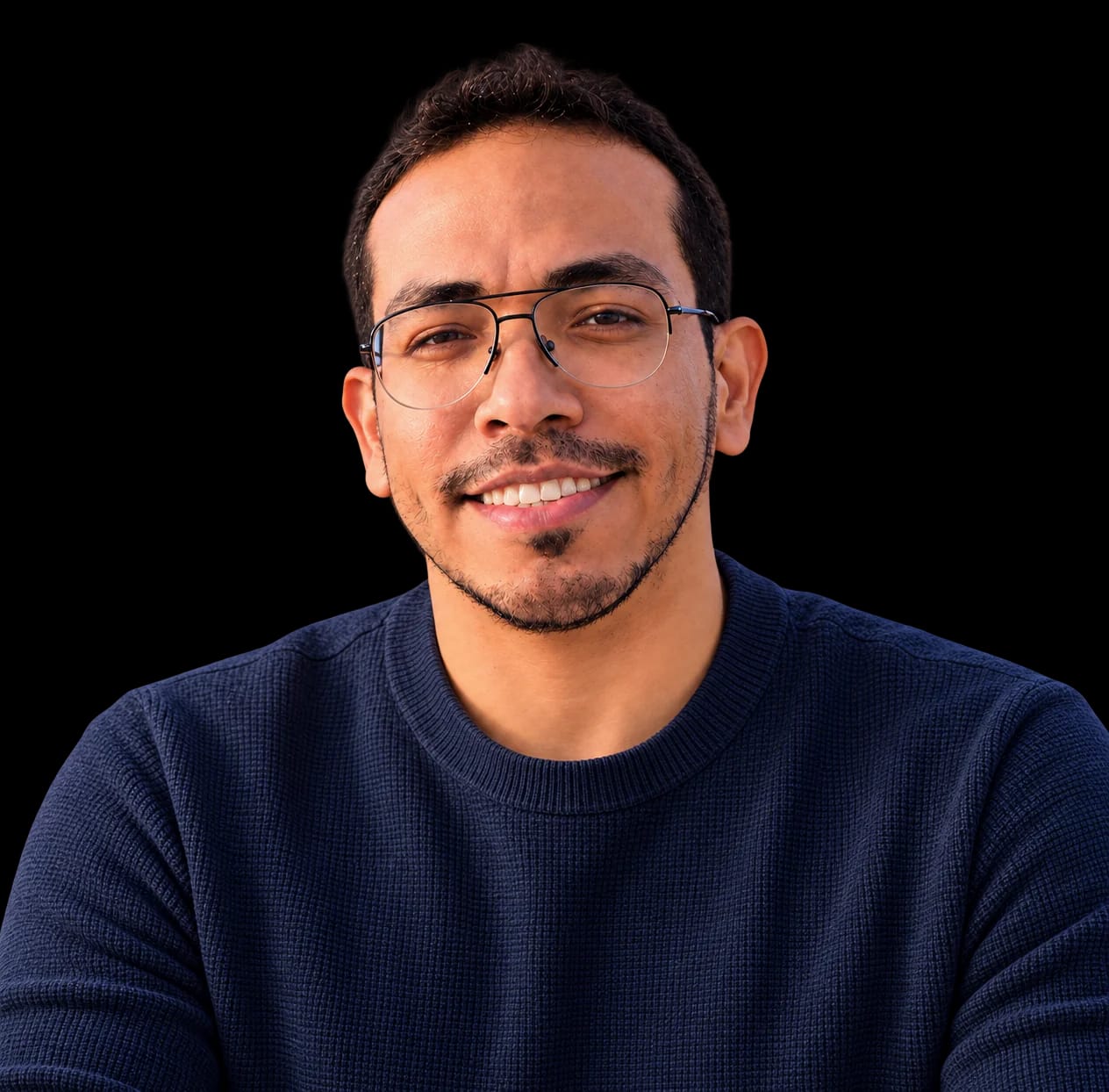 Retrato de Juan David Ramírez sonriendo, con gafas y suéter azul oscuro